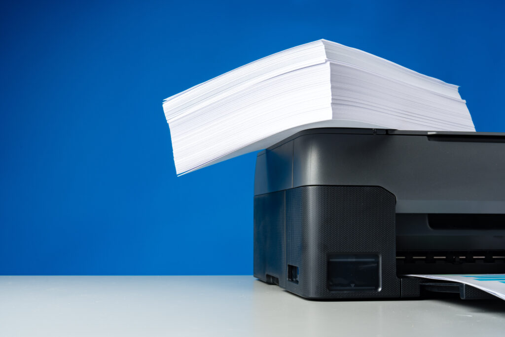 laser printer on desk against blue background.